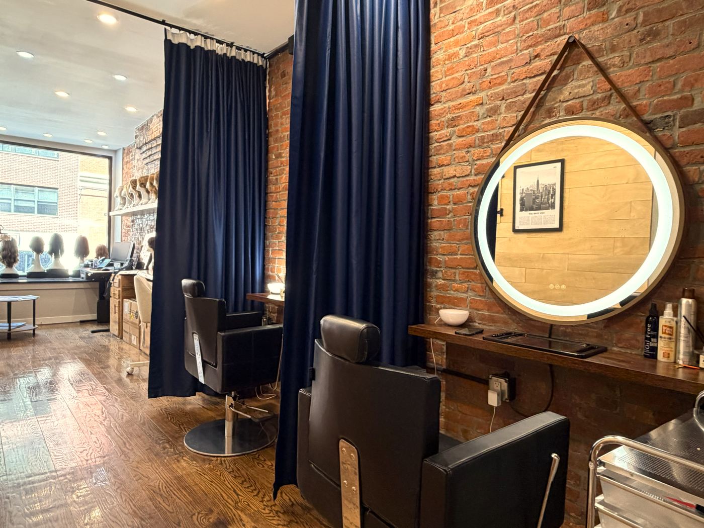Round LED vanity mirror and exposed brick at the Gen'C Chelsea salon